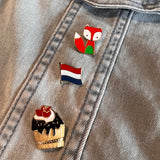 Nederland Hollandse Vlag Emaille Pin samen met een cupcake en ene vos pin op een spijkerjasje