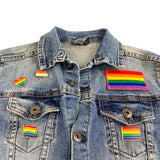 Rainbow Regenboog Vlag Gay Pride Symbool Emaille Pin samen met andere regenboog pins en een regenboog vlag op een spijkerjasje