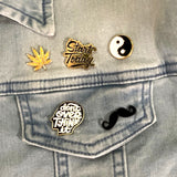 Close-up van de Marihuana Cannabis Hennep Wiet Weed  Emaille Pin samen met vier ander emaille pins op een spijkerjack