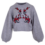Rode Bloesem Linker Tak Strijk Embleem Patch samen met de rechter variant op een grijze sweater