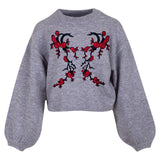 Rode Bloesem Rechter Tak XL Strijk Embleem Patch samen met de linker variant op een grijze sweater