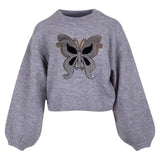 Vlinder Op Naai Embleem Patch Reversible Paillette Zilver Rood op een grijze sweater