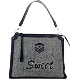 Sweet Tekst Strijk Strass Patch samen met een strass rangembleem op een grijze handtas