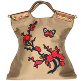 Rode Bloesem Linker Tak Strijk Embleem Patch samen met een vlinder patch op een goudkleurige tas