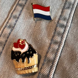 Cupcake Met Donker Bruine Glazuur Emaille Pin samen met de Nederlandse vlag pin 