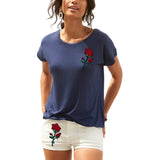 Roos Rozen Bloem Strijk Applicatie Patch op een donkerblauw t-shirt en een korte witte broek