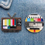 Testbeeld TV Retro Emaille Pin samen met een retro televisie TV pin met testbeeld op een ondergrond van denim
