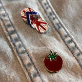 Tomaat Emaille Pin samen met een teenslipper pin met de print van de engelse vlag