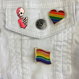 Geraamte Skelet Emaille Pin Oud Roze samen met twee regenboog pins op een wit spijkerjack