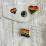 Rainbow Heart Regenboog Hartje Gay Pride Symbool Emaille Pin S samen met de grotere variant en een vlag pin op een wit spijkerjasje