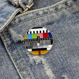 Testbeeld TV Retro Emaille Pin op een achtergrond van spijkerstof
