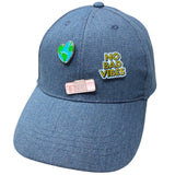 NO BAD VIBES Tekst Emaille Pin samen met een vitage roze radio pin en hartje van de aarde pin op een cap van spijkerstof