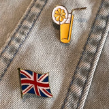 Limonade Cocktail Rietje Fruitschijfje Emaille Pin. samen met een britse vlag emaille pin op een spijkerjasje