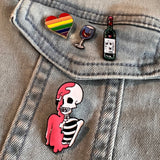 Geraamte Skelet Emaille Pin Oud Roze samen met drie andere emaille pins op een spijkerjasje