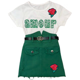 Twee maal de Roos In Knop Strijk Embleem Patch op zowel een wit t-shirt als op een groen kort rokje