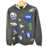 Alien Peace Sign Strijk Embleem Patch samen met andere ruimtevaart patches op een grijze hoodie