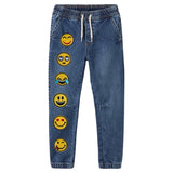 Ronde Gele Emoji Smiley Strijk embleem Patch Liefde samen met vijf andere emoji strijk patches uit dezelfde serie op een broekspijp van een kleine spijkerbroek