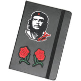 Klein Rood Roosje Strijk Patch Links samen met het rechter roosje en een andere strijk patch op de voorzijde van een zwarte agenda