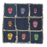 Multicolor Sugar Skull Strijk Patch Set met acht sugar skulls scht verschillende kleuren op een blauw sierkussen van spijkerstof