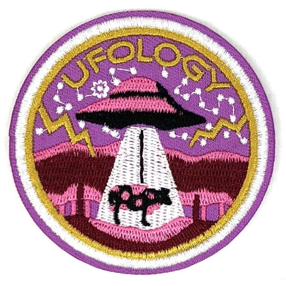 Ronde roze patch met daarop een UFO en de tekst ufology 