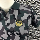 Legergroene Camouflage Military Tekst Embleem Strijk Patch op een camouflage groen polo shirt