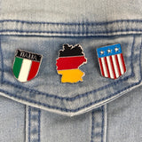 Bondsrepubliek Duitsland Vlag Emaille Pin samen met een pin van Amerika en Italie op een achtergrond van blauwe spijkerstof