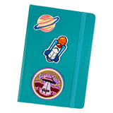 Planeet Ring Strijk Embleem Patch samen met een raket en UFO strijk patch op de voorzijde van een blauwe agenda