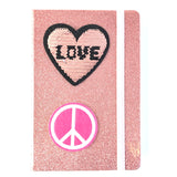 Rond Roze Peace Teken Strijk Embleem samen met een reversible pailletten hart strijk embleem op een roze glitter agenda