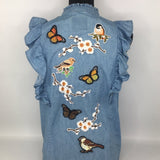 Donker Bruine En Zwarte Vlinder Patch samen met andere strijk patches van vlinders, vogels en bloesem takjes op een blauw spijkerstof shirt