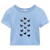 Vlinder Strijk Embleem Applicatie Patch Blauw samen met 11 andere kleuren van deze vlinder patch op een blauw kort t-shirt