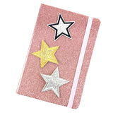 Zilver Kleurige Glitter Ster Met Zwarte Rand Strijk Patch samen met een zilverkleurige en goudkleurige ster patch op de voorkant van een roze glitter agenda