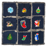 Kerst Rendier Kerstman Strijk Embleem Patch samen met acht andere kerst winter strijk patches op een kussenhoesje van spijkerstof