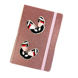 Twee Vlinder Strijk Embleem Patch Zwart Rood Roze op de voorzijde van een roze glitter agenda