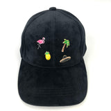 vier pin op ee zwarte cap waaronder een flamingo sombrero palmboom en ananas pin