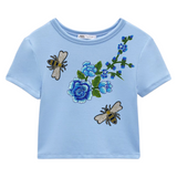 Bij Bijen Insect Strijk Embleem Patch samen met een opnaai bloemen tak op een lichtblauw t-shirtje