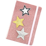 Goud Kleurige Glitter Ster Met Zwarte Rand Strijk Patch samen met twee zilverkleurige ster patches op de voorkant van een roze glitter agenda