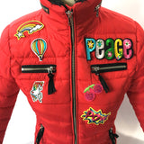 Kleine eenhoorn strijk patch met regenboog kleuren samen met andere gelijk kleurige strijk patches op een rode winterjas