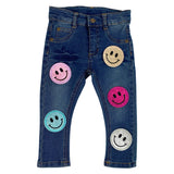 Blauwe Glitter Smiley Emoji Strijk Embleem Patch samen met vier andere glitter smiley strijk patches op een kleine spijkerbroek