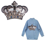 XXL strijk patch van een kroon die bedekt is met goud, zwarte en zilverkleurige pailletten op de achterzijde van een lichtblauwe spijkerblouse 