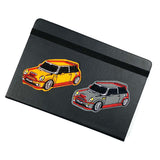 De oranje en grijze Engelse Mini Cooper Auto Embleem Strijk Patch op de voorzijde van een zwart leren agenda