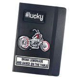 Lucky Hashtag Strijk Embleem Patch Zwart Wit samen met een motor en tekst strijk patch op de voorzijde van een zwarte agenda
