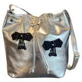 Twee maal de Strijk Opnaai Fashion Part Zwart Vijf Hangers op een zilverkleurige tas