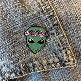 Emaille Pin Van Groen Alien Hoofd Met Bloemen Krans op het kraagje van een blauw spijkerjasje