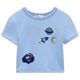 Raket Rocket Strijk Embleem Patch samen met andere strijk patches op een klein lichtblauw t-shirtje