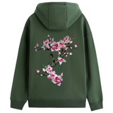 Magnolia Bloesem Tak XXL Strijk Embleem Patch Roze op de achterzijde van een groen hoodie