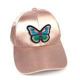 Blauw groene vlinder patch met veel kleine witte oogje op een roze cap