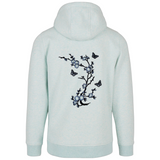 drie maal de Vlinder Strijk Embleem Applicatie Patch Grijs samen met een grijze bloesem bloem tak op een lichtblauwe hoodie