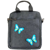 Twee Lichtblauwe Vlinder Strijk Patches op een zwarte canvas mannen tas