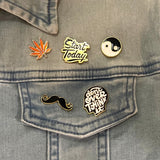 Close-up van de Yin Yang Emaille Pin samen met vier andere pins
